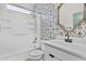 Bathroom with decorative tile accent wall, tub-shower combination, and framed mirror at 9727 E Torino Ave, Mesa, AZ 85212