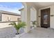 Inviting entrance featuring an arched entryway, elegant light fixtures and potted plants at 9727 E Torino Ave, Mesa, AZ 85212
