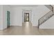 Bright foyer with hardwood floors, modern staircase, and a stylish teal-colored door at 9727 E Torino Ave, Mesa, AZ 85212