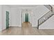 Bright foyer with hardwood floors, modern staircase, and a stylish teal-colored door at 9727 E Torino Ave, Mesa, AZ 85212