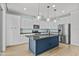 Modern kitchen features white cabinetry, a blue island, stainless steel appliances and modern pendant lighting at 9727 E Torino Ave, Mesa, AZ 85212
