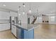 Open-concept kitchen includes a blue island and stainless steel appliances at 9727 E Torino Ave, Mesa, AZ 85212