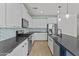 Modern kitchen features stainless appliances, white cabinets, an island and light wood flooring at 9727 E Torino Ave, Mesa, AZ 85212