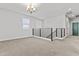Upstairs loft area with neutral carpeting and modern chandelier at 9727 E Torino Ave, Mesa, AZ 85212