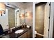 Bathroom with wood cabinets, granite counter, and a view to the toilet and shower at 9842 E Celtic Dr, Scottsdale, AZ 85260