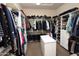 Spacious walk-in closet with ample shelving, hanging space, and central island for organization and storage at 9842 E Celtic Dr, Scottsdale, AZ 85260