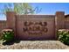 Charming entrance to Madrid community with stone sign and lush landscaping at 9842 E Celtic Dr, Scottsdale, AZ 85260