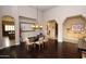 Open dining area featuring hardwood floors, modern lighting, and arched doorways leading to living areas at 9842 E Celtic Dr, Scottsdale, AZ 85260