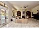 Spacious living room featuring tile floors, a stone fireplace, and doors to a patio with pool at 9842 E Celtic Dr, Scottsdale, AZ 85260