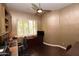 Home office featuring wood floors, built-in shelving, and shuttered windows, providing a sophisticated workspace at 9842 E Celtic Dr, Scottsdale, AZ 85260