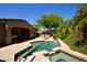 Backyard showcasing a stunning pool, spa, and built-in grill with lush greenery and outdoor seating areas at 9842 E Celtic Dr, Scottsdale, AZ 85260
