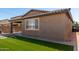Large backyard showcasing lush artificial grass, a covered patio, and a well-kept exterior at , Avondale, AZ 85323
