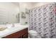 Bathroom featuring a vanity, toilet, mirror and shower with patterned shower curtain at , Avondale, AZ 85323