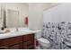 Well-lit bathroom with vanity, toilet, mirror and shower with floral shower curtain at , Avondale, AZ 85323