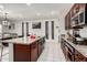 Spacious kitchen with dark wood cabinets, granite counters, stainless appliances, and an island with barstool seating at , Avondale, AZ 85323