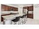 Modern kitchen features granite countertops, stainless steel appliances, dark wood cabinets, and breakfast bar seating at , Avondale, AZ 85323