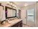 Bathroom featuring dark wood vanity, tile countertop and floors, decorative mirror and modern lighting at 10522 E Bella Vista Dr, Scottsdale, AZ 85258