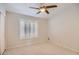 Well-lit bedroom with a ceiling fan and window with white shutter, offering ample space and natural light at 10522 E Bella Vista Dr, Scottsdale, AZ 85258