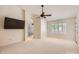 Spacious main bedroom featuring a ceiling fan, a TV and an archway leading to the en-suite bathroom at 10522 E Bella Vista Dr, Scottsdale, AZ 85258