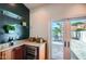 Granite wet bar with glass shelves, a wine fridge, and outdoor access to the pool area at 10522 E Bella Vista Dr, Scottsdale, AZ 85258
