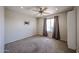 Neutral carpeted bedroom with lighted ceiling fan, window with curtains, and wall mounted TV bracket at 10858 E Sahuaro Dr, Scottsdale, AZ 85259