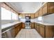 Kitchen with stainless steel appliances, a bright window and wooden cabinetry at 10858 E Sahuaro Dr, Scottsdale, AZ 85259
