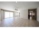 Spacious living room featuring tile floors, neutral walls, ceiling fan, and back patio access at 10858 E Sahuaro Dr, Scottsdale, AZ 85259