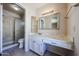 Main bathroom with marble-look vanity, modern lighting fixtures, and a walk-in shower with glass doors at 10858 E Sahuaro Dr, Scottsdale, AZ 85259