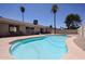 A sparkling blue pool is surrounded by a concrete patio and the house with large sliding glass doors at 10858 E Sahuaro Dr, Scottsdale, AZ 85259