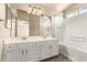 Bright bathroom featuring double sinks with white cabinetry and shower-tub combo at 1334 E Helena Dr, Phoenix, AZ 85022
