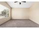 Bedroom with neutral paint and carpet features a large window with blinds and a ceiling fan at 1334 E Helena Dr, Phoenix, AZ 85022