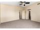 Bedroom with neutral paint and carpet features a large window, ceiling fan and closet doors at 1334 E Helena Dr, Phoenix, AZ 85022