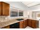 Bright kitchen features granite countertops, tile backsplash, black appliances and double sink under a window at 1334 E Helena Dr, Phoenix, AZ 85022