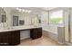 Primary bathroom featuring double vanity, soaking tub, and large window at 13420 W Berridge Ln, Litchfield Park, AZ 85340