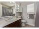 Neutral bathroom features a single sink vanity with dark cabinets, plus a toilet and shower at 13420 W Berridge Ln, Litchfield Park, AZ 85340