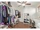 Bright walk-in closet featuring an open shelving system and dark hardwood floors at 13420 W Berridge Ln, Litchfield Park, AZ 85340