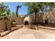 Outdoor fireplace feature with stone pavers and surrounding desert landscaping in backyard at 13420 W Berridge Ln, Litchfield Park, AZ 85340