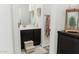 Bathroom featuring a dark vanity, framed mirror, and wall-mounted towel rack at 14344 W Hackamore Dr, Surprise, AZ 85387