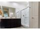 Contemporary bathroom with double sinks, a glass-enclosed shower, and neutral tones at 14344 W Hackamore Dr, Surprise, AZ 85387