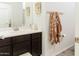 Bathroom featuring a double sink vanity, framed mirror, and wall-mounted towel rack at 14344 W Hackamore Dr, Surprise, AZ 85387