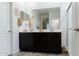 Modern bathroom featuring double sinks, a large mirror, and tile flooring at 14344 W Hackamore Dr, Surprise, AZ 85387