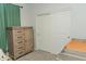 Bedroom featuring neutral paint, a light-colored dresser with drawers, and a sliding door closet at 14344 W Hackamore Dr, Surprise, AZ 85387