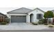 Charming single-story home with a well-maintained front yard and gray accent garage door at 14344 W Hackamore Dr, Surprise, AZ 85387