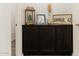 Hallway decor on a dark cabinet with decorative accents and a framed picture at 14344 W Hackamore Dr, Surprise, AZ 85387