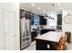 Bright, open kitchen featuring a granite island, stainless steel appliances, and stylish pendant lighting at 14344 W Hackamore Dr, Surprise, AZ 85387