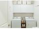 Bright laundry room featuring a washer and dryer and ample storage cabinets at 14344 W Hackamore Dr, Surprise, AZ 85387