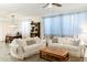 Cozy living room with sofas, wood coffee table, neutral rug, tile flooring, and lots of natural light at 14344 W Hackamore Dr, Surprise, AZ 85387