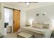 Cozy bedroom with a sliding barn door to the bathroom and neutral decor at 14344 W Hackamore Dr, Surprise, AZ 85387
