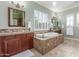 Luxurious bathroom featuring a soaking tub, dual vanities, and plenty of natural light at 14426 W Becker Ln, Surprise, AZ 85379