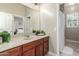 Well lit bathroom featuring a vanity with a large mirror, neutral walls, and modern fixtures at 14426 W Becker Ln, Surprise, AZ 85379